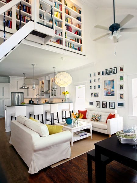 A bright living area with a loft with built-in bookcases