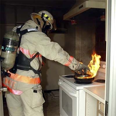 A firefighter putting out a kitchen fire
