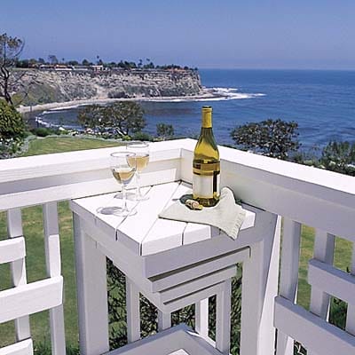 a small table at the corner of a deck used for drinks and snacks