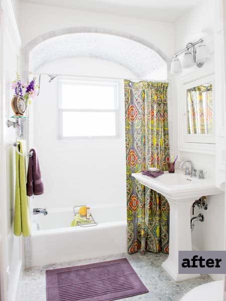 Bright renovated bathroom with white subway tile, arched tub enclosure and pedestal sink.