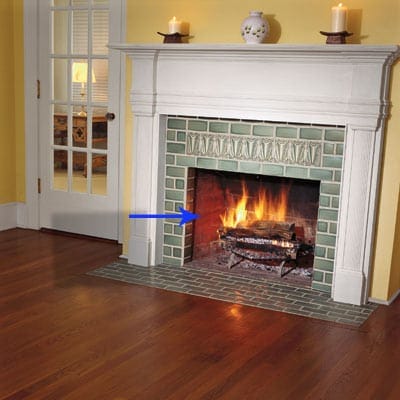 A fireplace with an arrow pointing out the pieces called the cheeks.