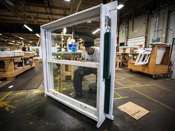 Factory floor showing windows and wall components being built indoors.