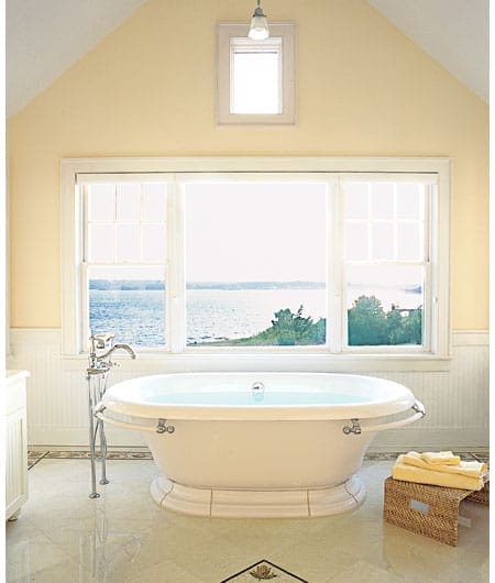 Bathroom with bathtub under a large picture window.