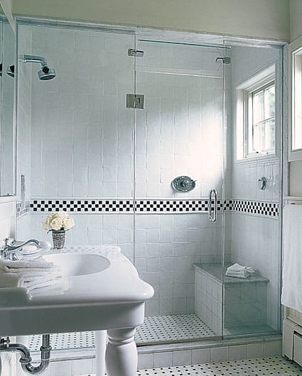 Master bathroom with white handmade tiles, curved console sink, and shower bench.