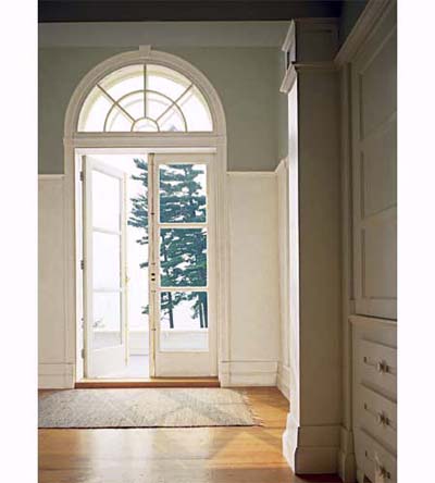Arched window with stock molding over a doorway.