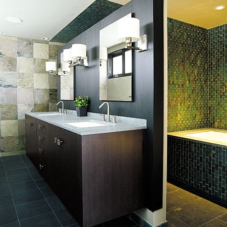 Modern bathroom with iridescent tiles around the bathtub.