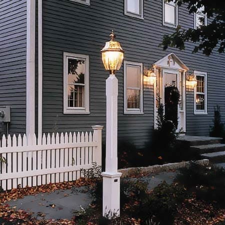 A post lantern and wall lanterns lighting up a house exterior.