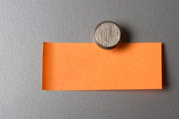 A magnet holding up a piece of paper