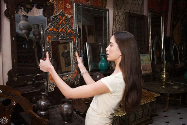 Woman evaluating antique mirror