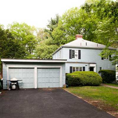 Colonial Revival house before renovation showing jutting garage with flat roofline.