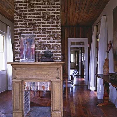 Open living and dining area with exposed wood walls and pass-through to kitchen.