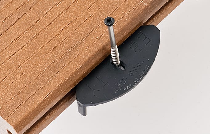 Close-up on a fastener and screw on a deck plank.