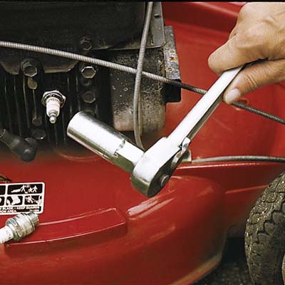 Performing lawn mower maintenance.