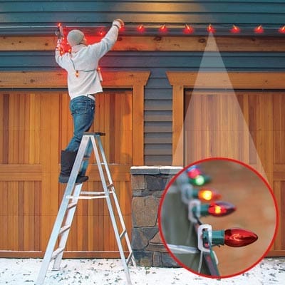 A man hanging Christmas lights