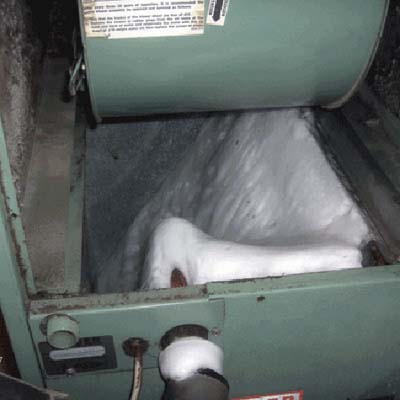 Air conditioning unit completely frozen with thick ice buildup.