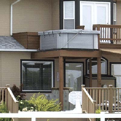 Hot tub on second-story deck without safety railings around perimeter.