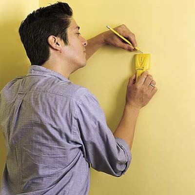 Person finding a stud in a wall