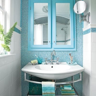Bathroom with azure penny tiles and pale blue cabinetry.