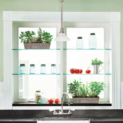 A kitchen window with glass shelves