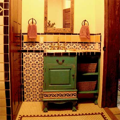 Rustic bathroom featuring hand-painted gold and blue tilework.
