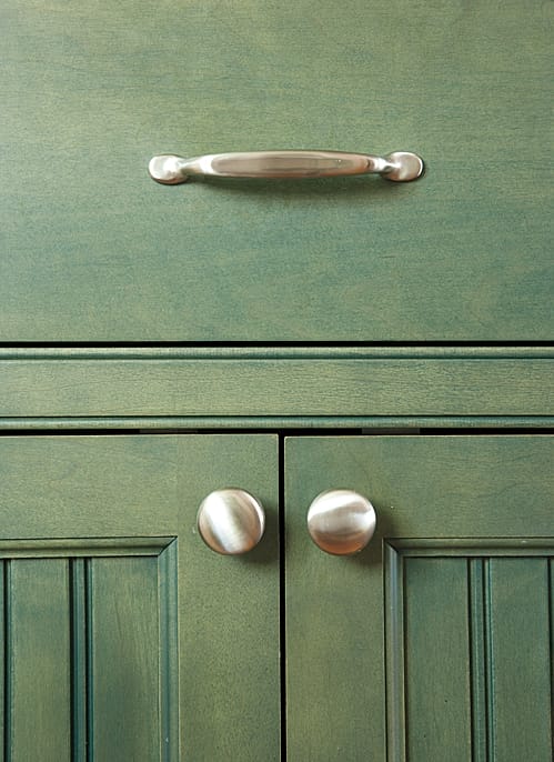 an up close view of the knobs and handles of the kitchen drawers and cabinets that give a rustic feel