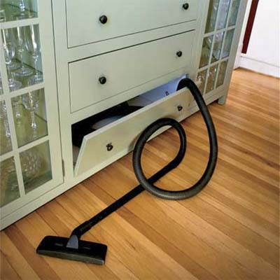 a vacuum cleaner that is hidden within a cabinet