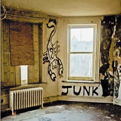 A room with spray paint graffiti and damage