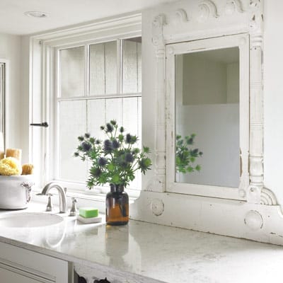 A bathroom counter with a salvaged mirror