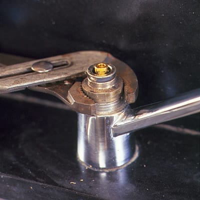 The retainer nut is freed using a wrench.