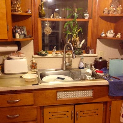 A full sink and wooden cabinets