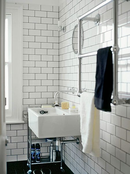 White subway tile bathroom with black grout creating bold geometric pattern.