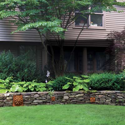 A stone wall in front of a house