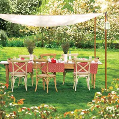 Wooden table and chairs in the middle of a garden.