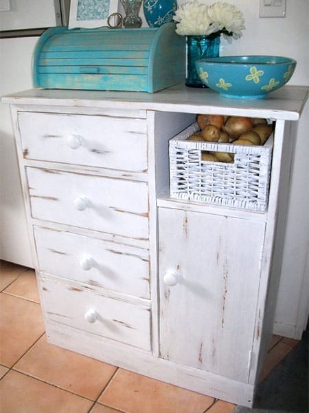 A distressed-look white kitchen cupboard.