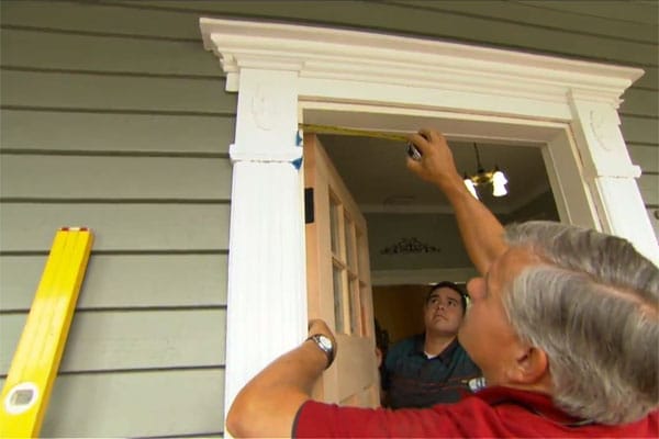 Tom Silva measures the top of a door frame for a fiberglass front door.