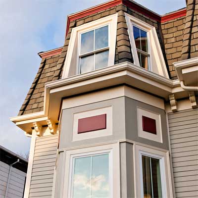 Second Empire house exterior with bright colors, corbels, and Victorian flourishes.
