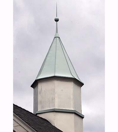 Standing-seam metal roof with custom tower feature.