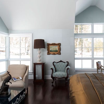 Bedroom with asymmetrical rooflines, corner windows, and luminescent paper wall tiles.