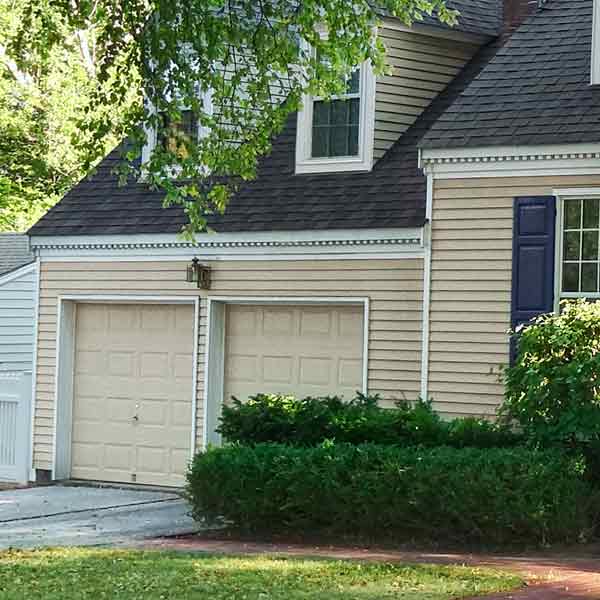 Close-up on two garage doors and clapboard siding.