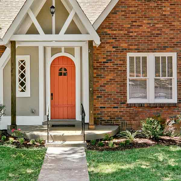 White painted double-hung windows on the Tudor house.