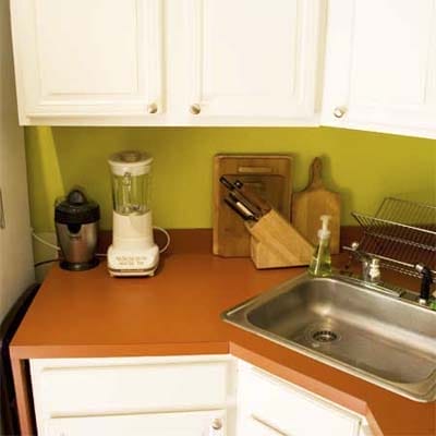 A small kitchen rearranged to make room for a fridge.