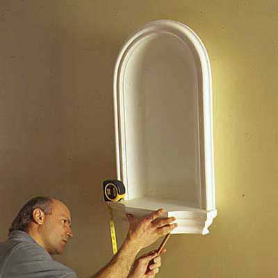 Man installing a decorative wall niche.