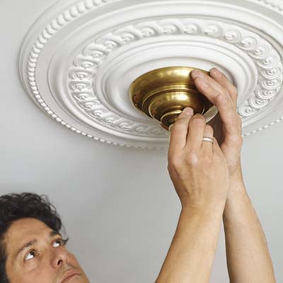 Man installing a ceiling medalion.