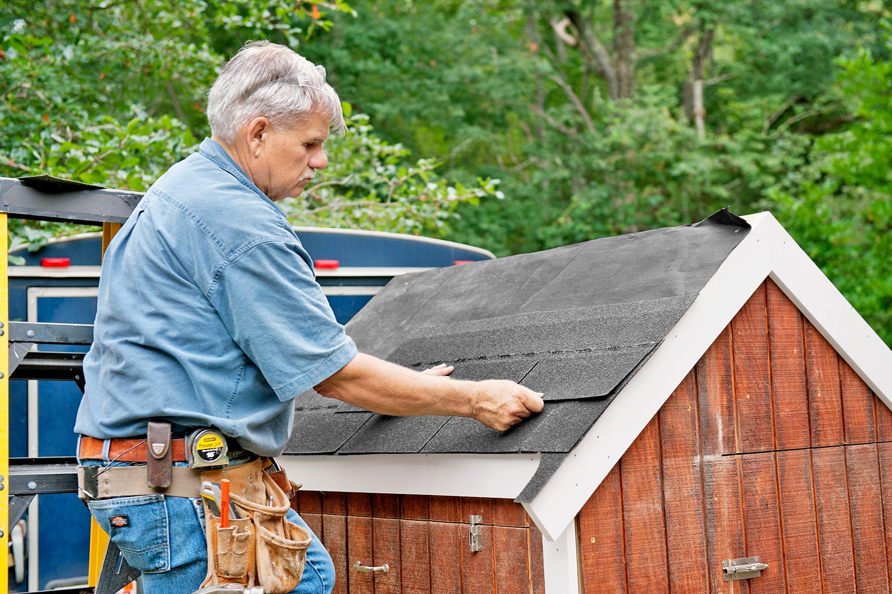 Tom Silva nails shingles on the chicken coop roof.
