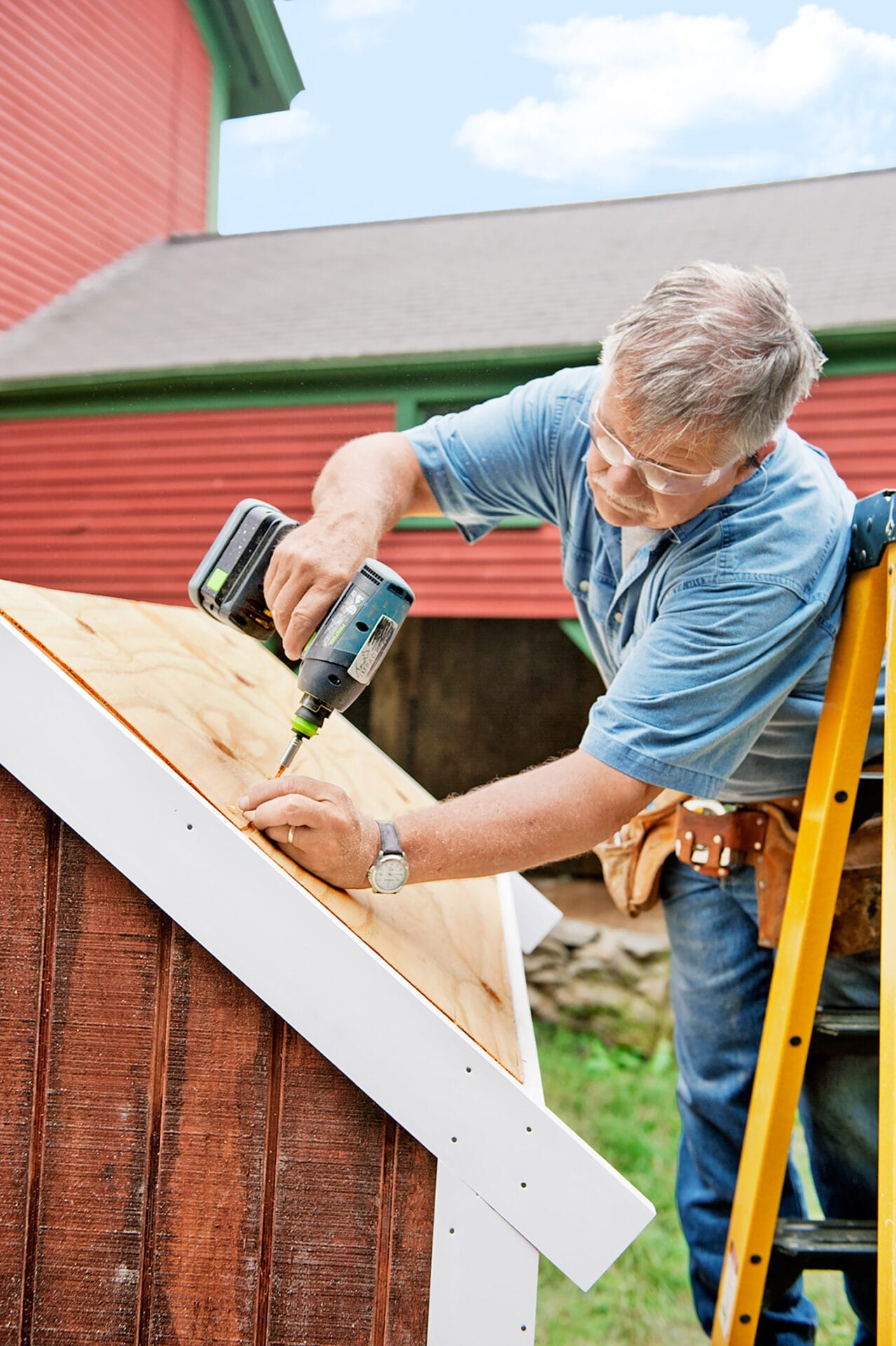 Tom Silva adds the trim onto the chicken coop.