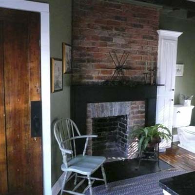 A chair next to a redone brick fireplace