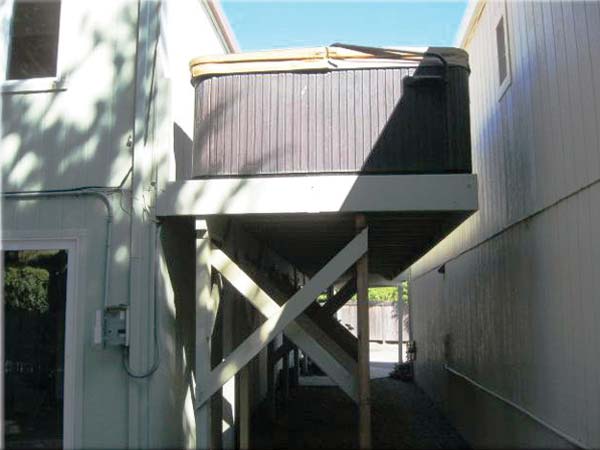 Hot tub on cantilevered deck without safety railings.