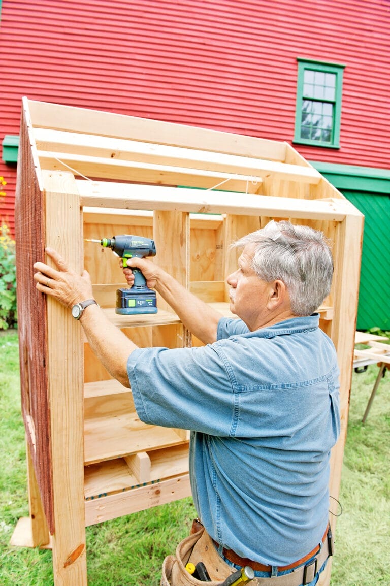 Tom Silva attaches the frame and nesting boxes to the coop.