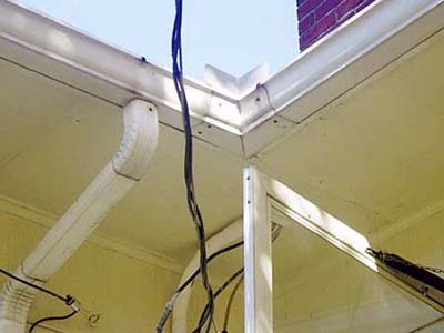 Electrical wires hanging dangerously low over exterior door opening.