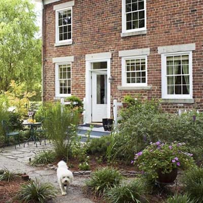 A brick house with a dog in front